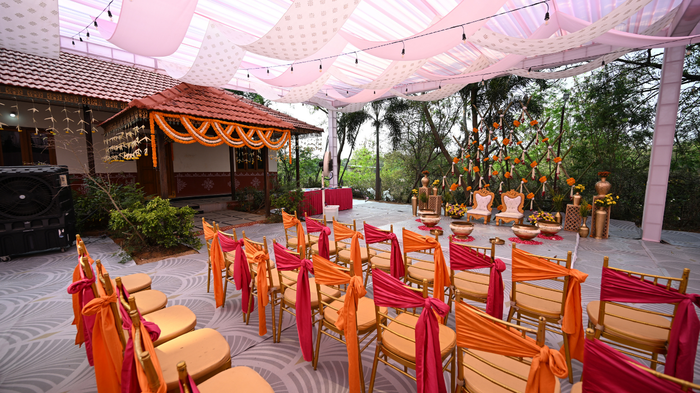 Haldi seating area with pink and orange chair decor under a soft canopy