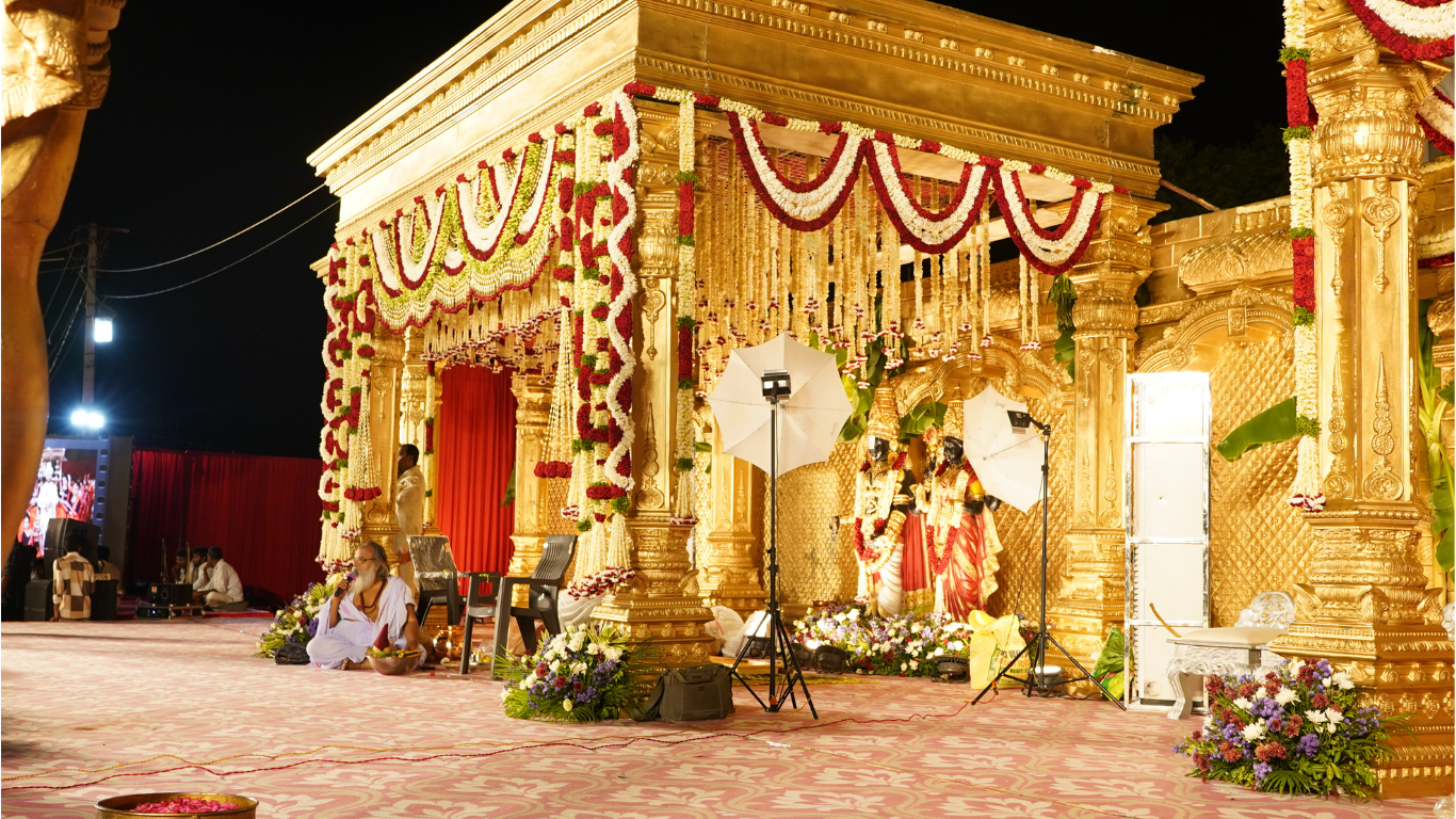 Side view of the golden wedding mandap with floral garlands and ceremonial setup