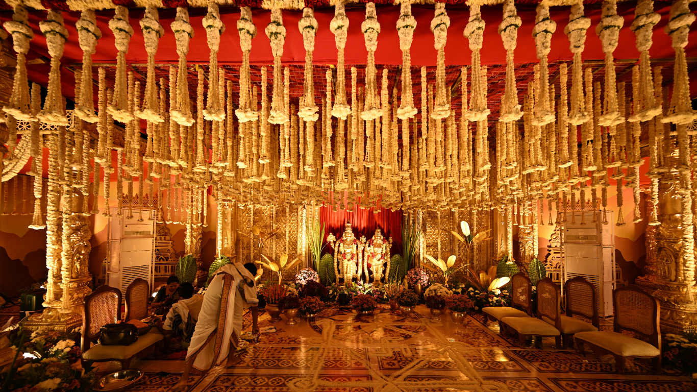 Mandap ceiling with cascading jasmine garlands and deity backdrop